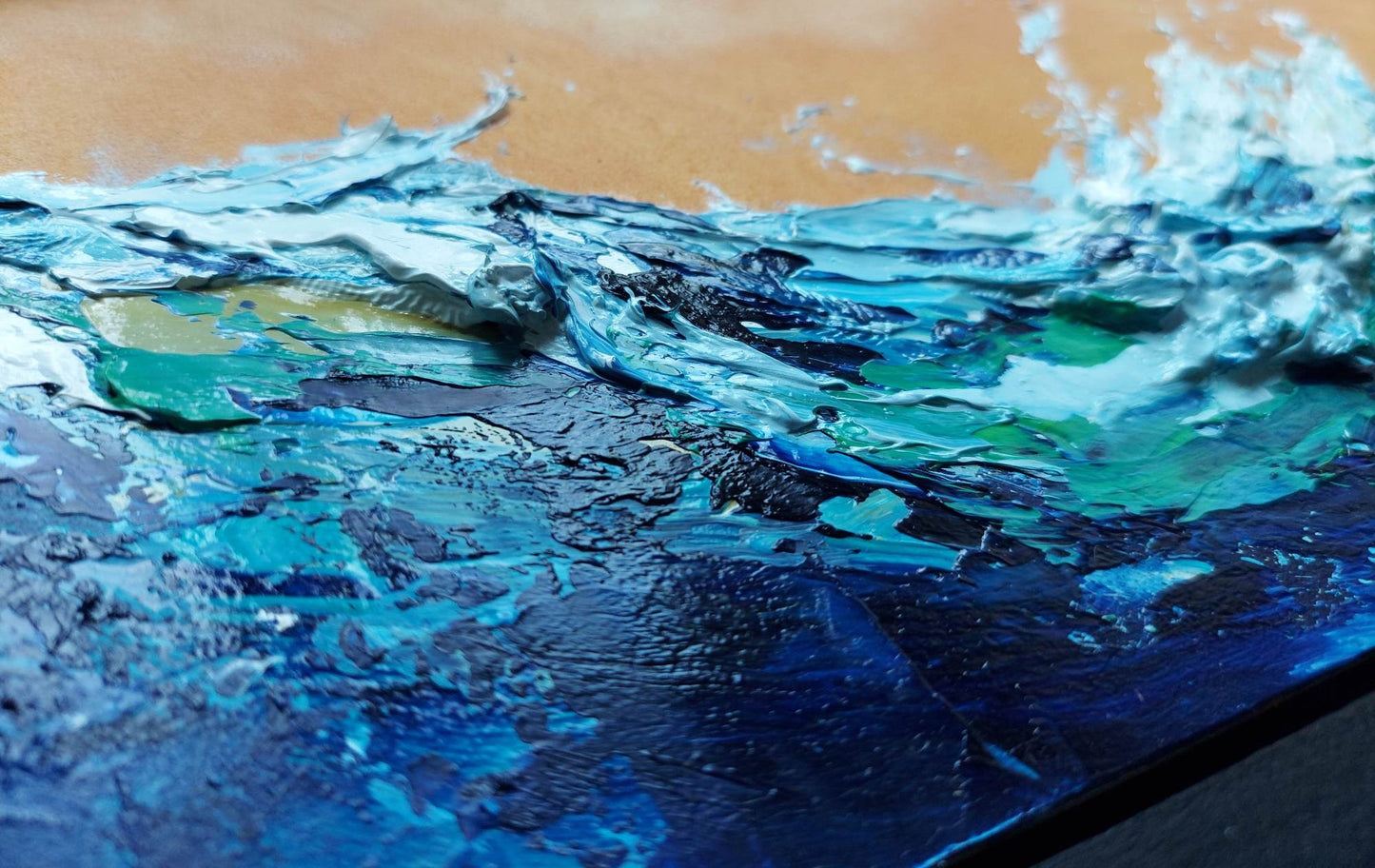 Close-up of a painting of a wave with blue and white colors.