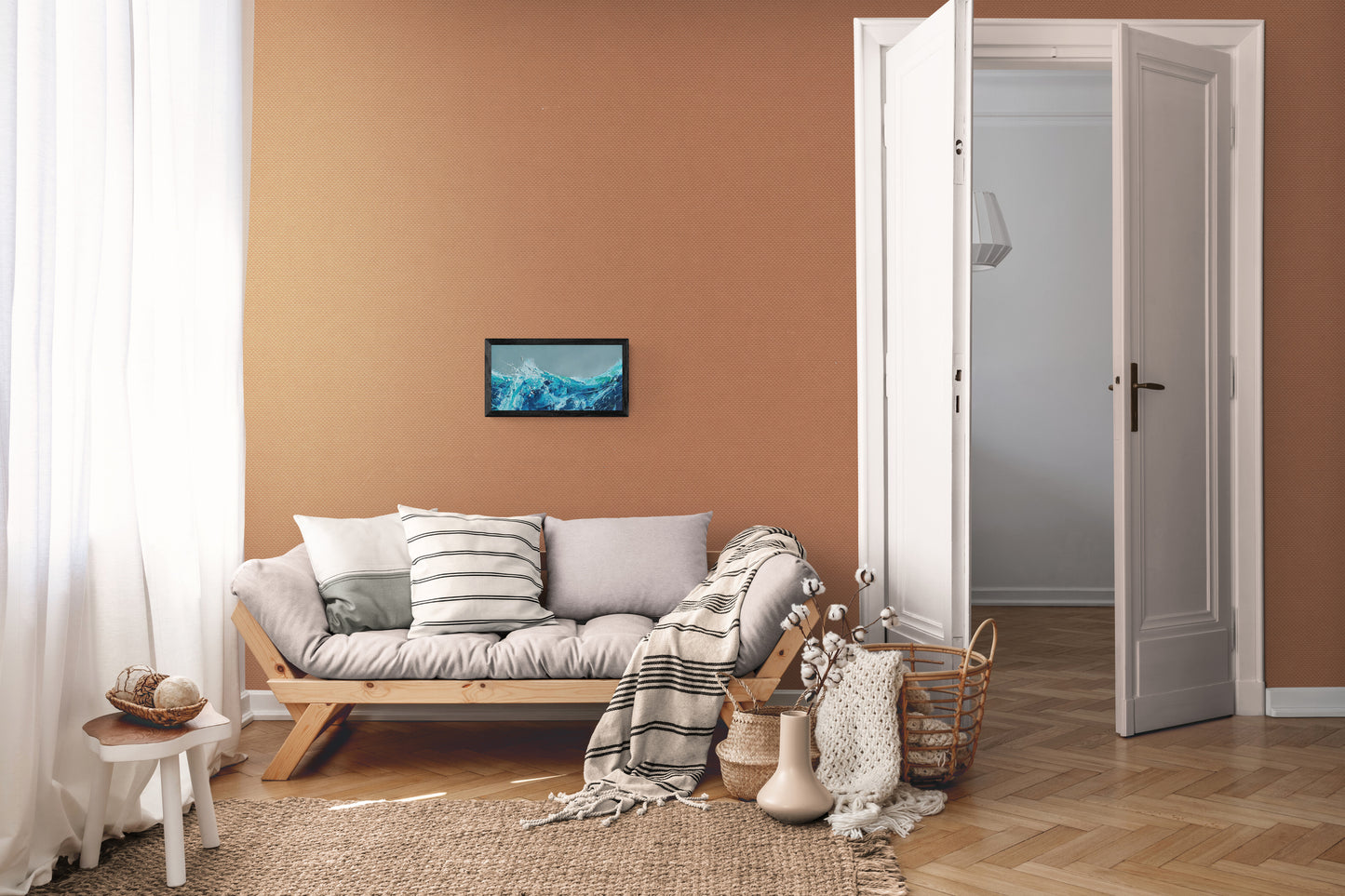 Living room with a sofa, coffee table, and decorative items against a brown wall showing an oil painting by Michael Hemming.