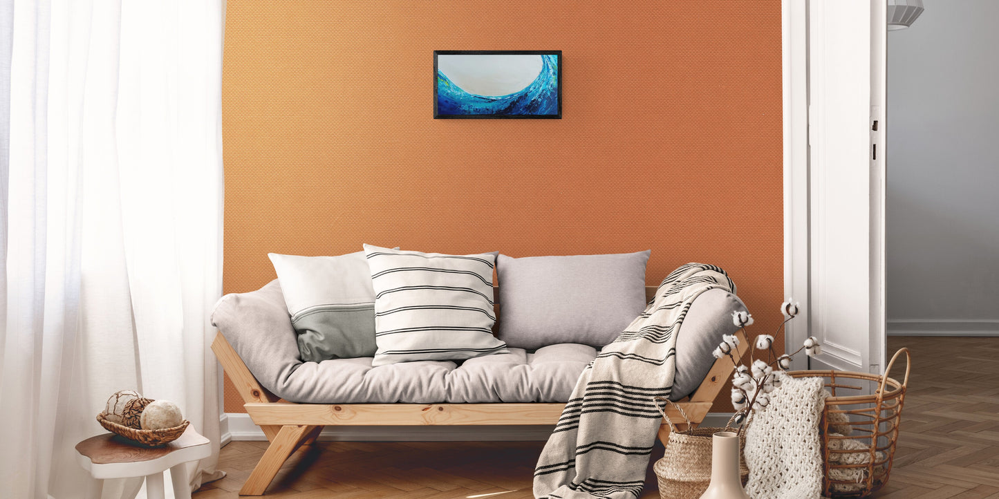 Living room with a gray sofa, striped cushions, and a framed picture on an orange wall.